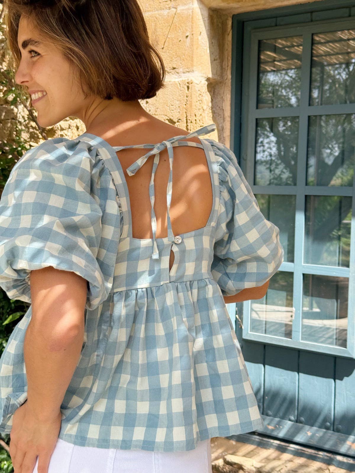 Nærbilde bakfra av åpen rygg og puffermer på klassisk blå gingham-bluse – Vycora Archive