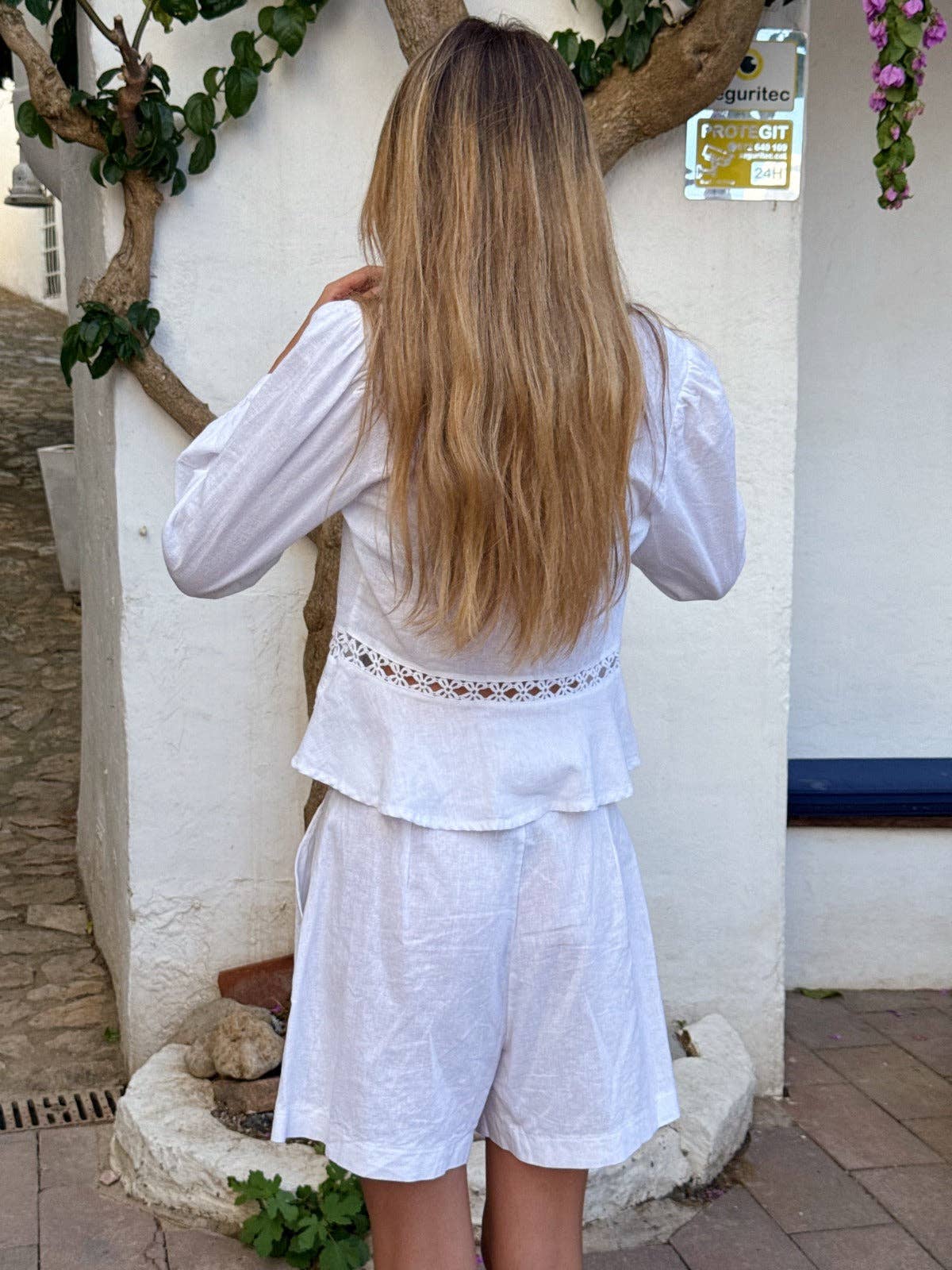 Modell bakfra i halvfigur som viser rent snitt og stille eleganse i hvit linblanding – Vycora Archive